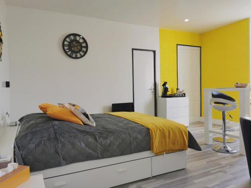 1 dormitorio con 1 cama y reloj en la pared en VITTEL LOC'S - LE 214, classé 3 étoiles OSEZ L'EXPERIENCE, en Vittel