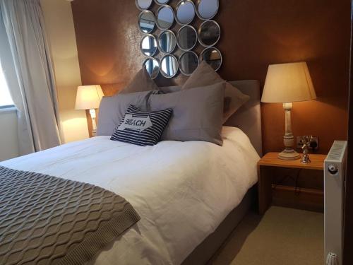 a bedroom with a large bed with a mirror on the wall at The Mews in Alderley Edge
