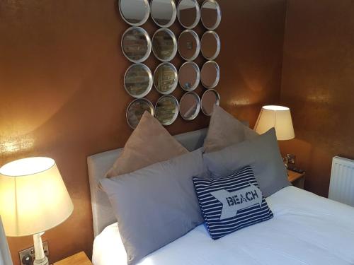 um quarto com uma cama com almofadas e pratos na parede em The Mews em Alderley Edge