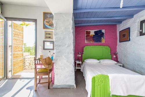 RóziaにあるLoukoum Syros Cycladesのピンクの壁のベッドルーム1室(緑のベッド1台付)