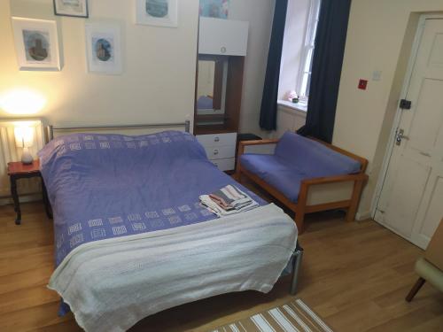 a bedroom with a bed and a chair and a window at HAVEN STUDIO GROUND FLOOR in Whitehaven