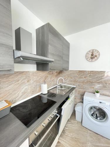 een keuken met een wastafel en een wasmachine bij Apartment Marina in Opatija