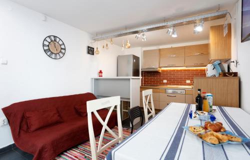 a kitchen and a living room with a red couch at Caraiman Hive in Buşteni
