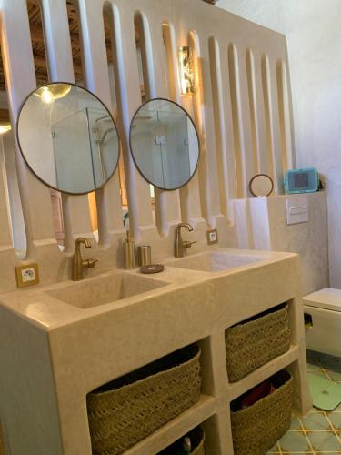 a bathroom with a sink and two mirrors at Dar Gecko in Sidi Kaouki