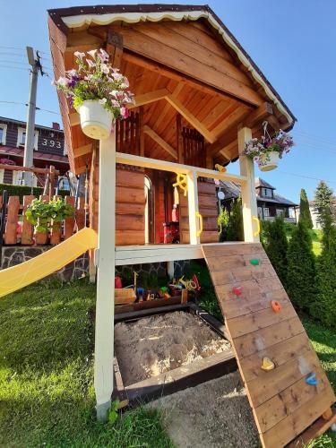 a wooden dog house with a staircase in the yard at Penzión Blanka in Ždiar