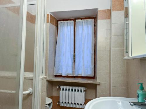 een badkamer met een wastafel en een raam bij Casa del Ciliegio in Valeggio sul Mincio