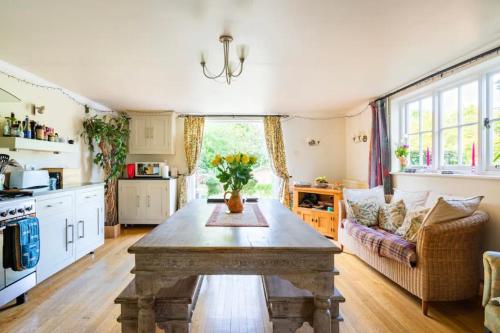 a kitchen with a table with a vase of flowers on it at The Tallow Factory in Dedham in Dedham