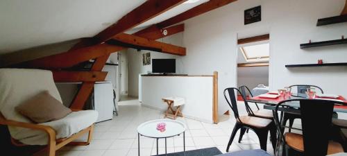 ラ・フェルテ・ゴシェにあるJolie Appartement 3 pièces avec Piscineのテーブルとダイニングルームのあるリビングルーム