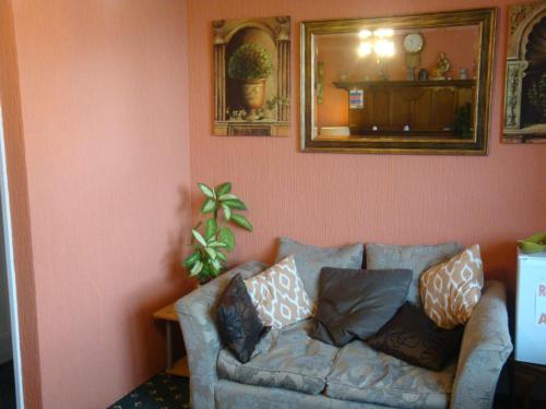 a living room with a couch and a mirror at Spencer Court in Ramsgate