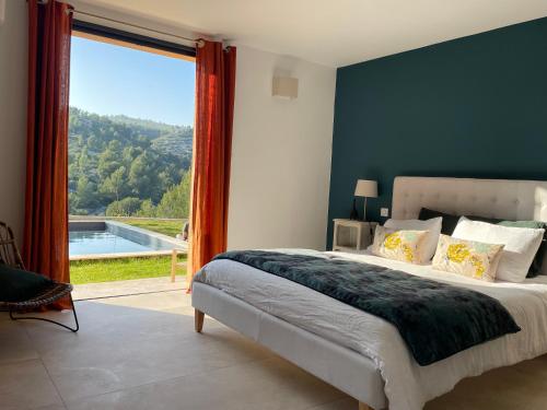 a bedroom with a large bed and a large window at AQUARIUS IN CASSIS, Chambres d'Hôtes in Cassis