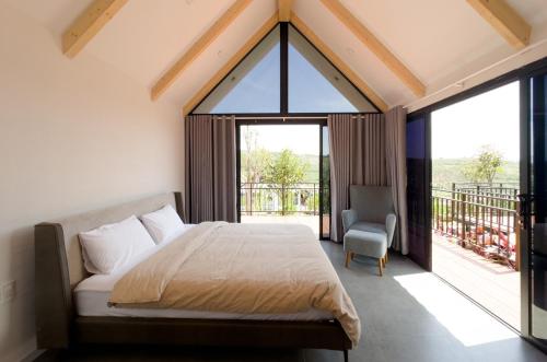 een slaapkamer met een bed en een groot raam bij Mya Lakeview Villa in Tang Jran Dring