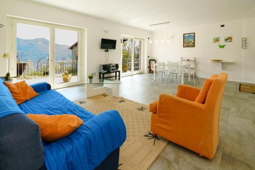 ジェーラ・ラーリオにあるAppartamento Alex - pace e relax sul Lago di Comoのリビングルーム(青いソファ、オレンジの椅子付)