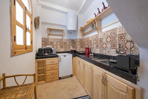 una pequeña cocina con fregadero y microondas en Dar BAB HAHA Petite Maison à la Marocaine, en Tánger
