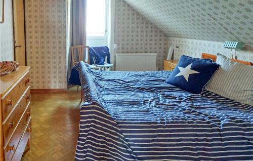 um quarto com uma cama com um edredão azul e branco em Stunning Home In Fridlevstad With Kitchen em Fridlevstad