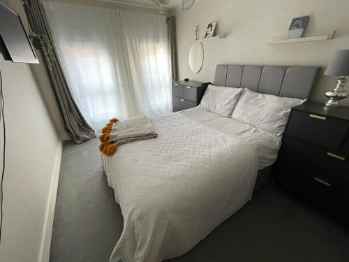 a bedroom with a white bed and a window at Central Mews House Altrincham in Altrincham