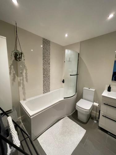 uma casa de banho com uma banheira, um WC e um lavatório. em Central Mews House Altrincham em Altrincham