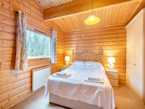 a bedroom with a bed in a wooden cabin at Holly Lodge - Uk37185 in Legbourne