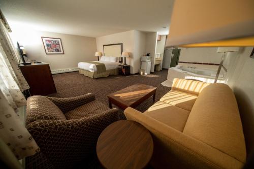 a hotel room with a couch and a bed at Coast Fort St John Hotel in Fort Saint John