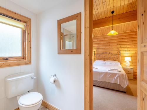 a bathroom with a bed and a toilet and a mirror at Holly Lodge - Uk37185 in Legbourne