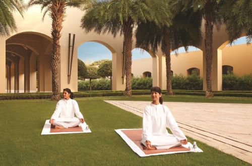 two women in white doing yoga in the grass at Trident Gurgaon in Gurgaon