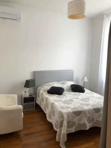 une chambre blanche avec un lit et une chaise dans l'établissement Agréable Maison avec jardin et terrasse, à Béziers