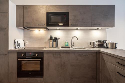 a kitchen with brown cabinets and a sink and a microwave at Mein Gaisberg in Obergurgl
