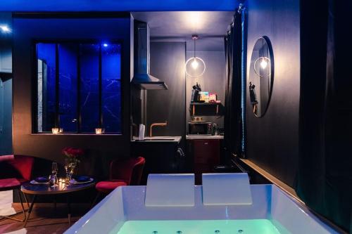 - une baignoire dans une chambre avec une table dans l'établissement Rêve d'or, à Rouen
