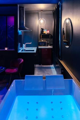a blue tub in a room with a sink at Rêve d'or in Rouen