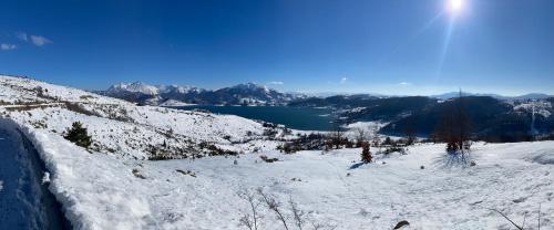 a view of a snow covered mountain with a lake at Casa vacanze Lago di Campotosto in Campotosto
