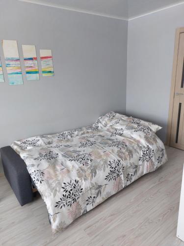uma cama com um edredão preto e branco num quarto em Jelena Apartment em Rezekne