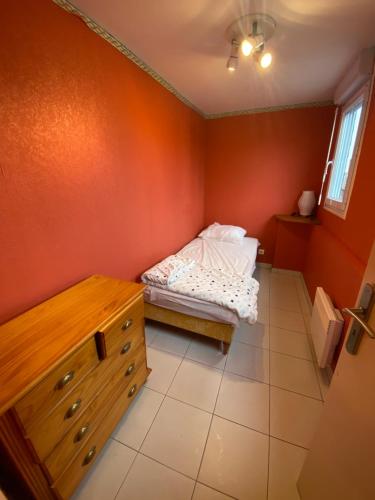 - une petite chambre avec un lit et une commode dans l'établissement Villa Garance, au Tréport