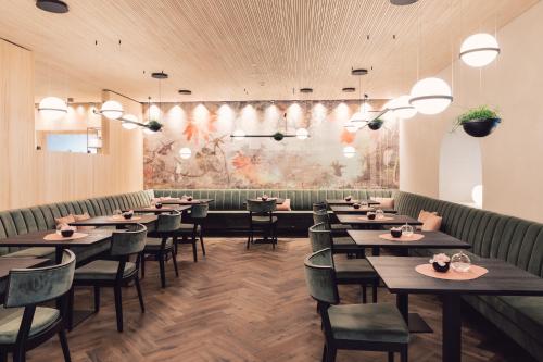 a dining room with tables and chairs and a mural at Seehotel Einwaller - adults only in Pertisau