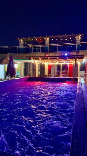 a swimming pool lit up at night with purple lights at Hotel Dubaird in Santo Domingo