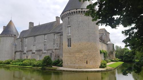 an old castle with a river in front of it at LEBAS-LADIN - Bayeux Ville Touristique in Lison