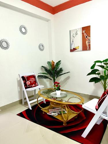 a living room with a glass table and a chair at Hotel Dubaird in Santo Domingo