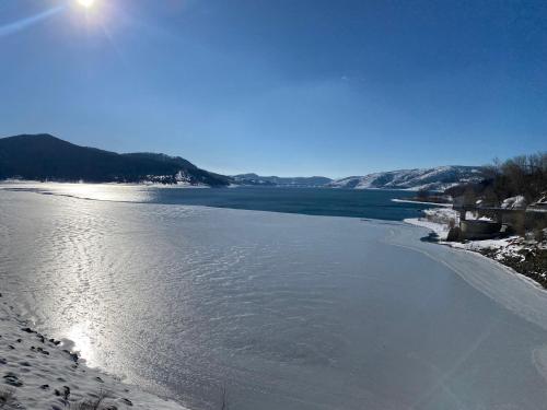 a body of water with snow on the shore at Casa vacanze Lago di Campotosto in Campotosto