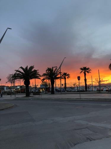 un tramonto con palme in un parcheggio di Coral Dream ad Alghero