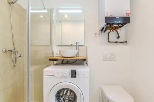 ein Badezimmer mit einer Waschmaschine und einem Waschbecken in der Unterkunft MyHouseSpain - Moderno piso en Embajadores in Madrid