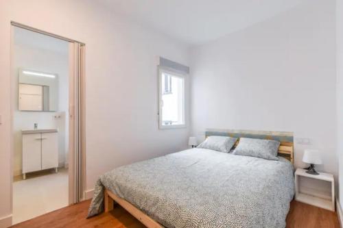 ein weißes Schlafzimmer mit einem Bett und einem Spiegel in der Unterkunft MyHouseSpain - Moderno piso en Embajadores in Madrid