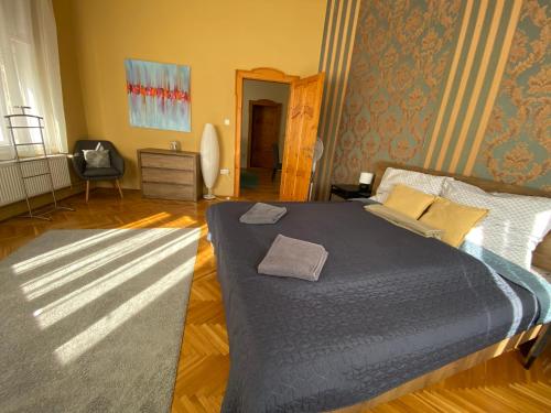 a bedroom with a large bed with a blue blanket at Ambrózia Apartman in Eger