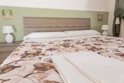 a bedroom with a large bed with a floral bedspread at Appartamento indipendente in villa in Sanremo