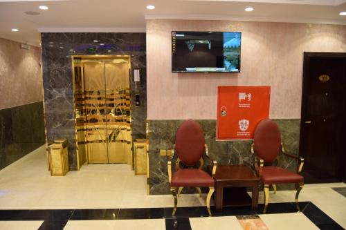 Sīdī Ḩamzahにあるفندق اللؤلؤة الذهبيの椅子2脚とテーブル付きの待合室
