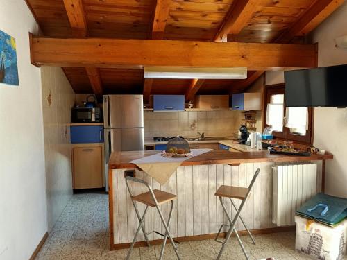 a kitchen with a counter and two chairs in it at Mon grenier in Aosta