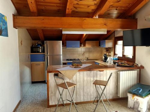 una cocina con encimera y 2 sillas. en Mon grenier en Aosta