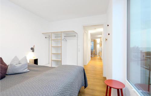 - une chambre blanche avec un lit et un tabouret rouge dans l'établissement Penthouse Comfort, à Lembruch