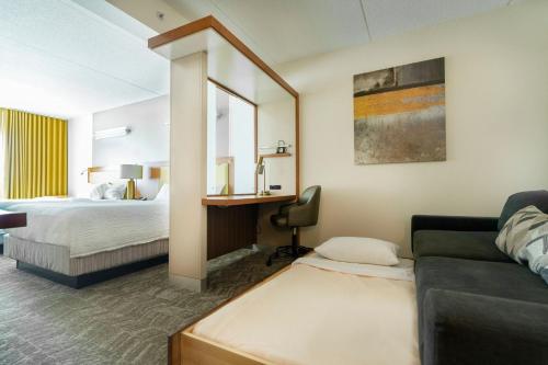 una habitación de hotel con un sofá y una cama en SpringHill Suites by Marriott Athens West, en Athens