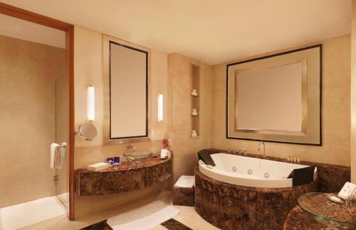 a bathroom with a large tub and a sink at Trident Gurgaon in Gurgaon