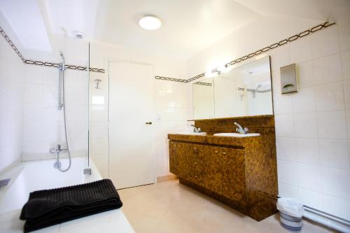 une salle de bain avec une baignoire, un lavabo et une douche dans l'établissement L’Atelier, à Saint-Denis-sur-Loire