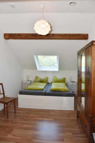 a bedroom with a bed with yellow pillows and a window at Historischer Bahnhof in Friedrichshafen