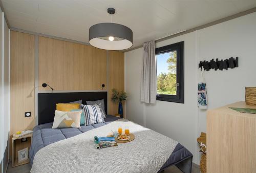 sypialnia z łóżkiem z tacą z jedzeniem w obiekcie Les Bungalows du California w mieście Pinarellu